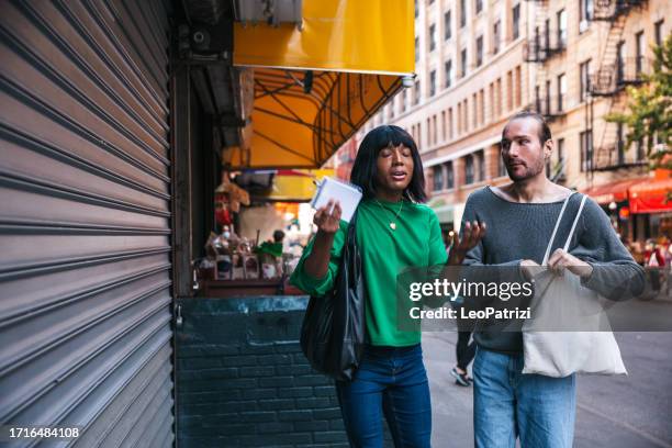 transgender couple exploring chinatown in lower manhattan - shopping disappointment stock pictures, royalty-free photos & images