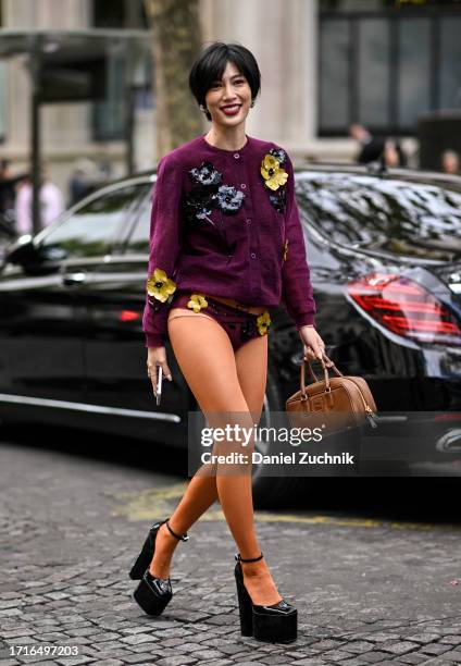 Molly Chiang is seen wearing a maroon floral Miu Miu cardigan, Miu Miu floral underwear and orange tights, black shoes with a brown Miu Miu bag...