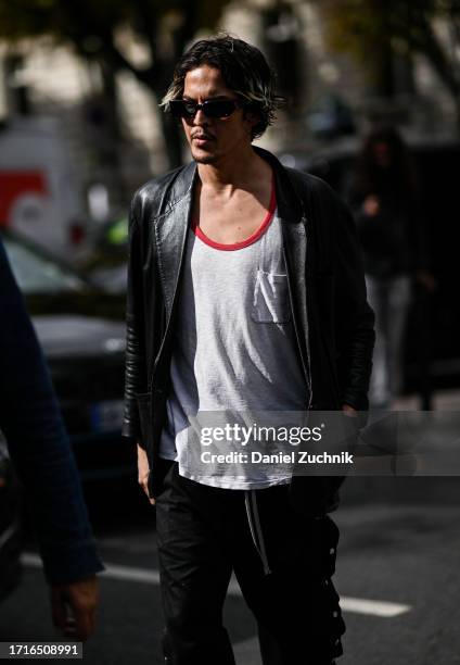 Guest is seen wearing a black leather jacket, white shirt and black pants with black sunglasses outside the Miu Miu show during the Womenswear...