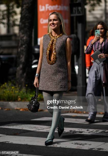 Guest is seen wearing a Miu Miu twill dress with a black Miu Miu bag outside the Miu Miu show during the Womenswear Spring/Summer 2024 as part of...