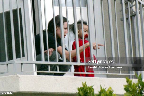 Actress Angelina Jolie plays with her son, Maddox, on the balcony of a hotel on December 30, 2002 in Beverly Hills, California.