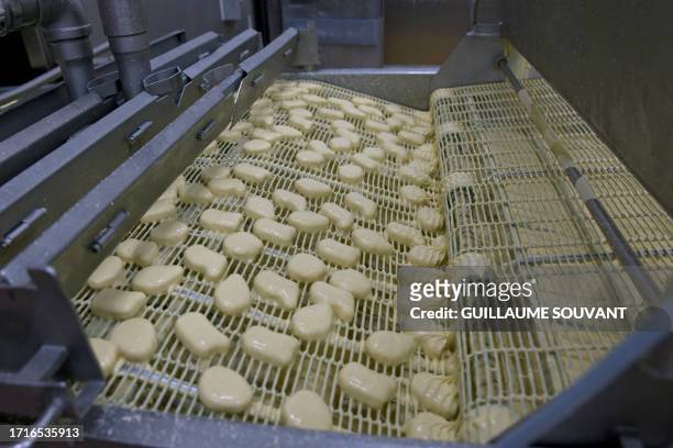 This picture taken on October 9, 2023 shows food factory Cargill's conveyor belt while chicken nuggets are being breaded inside the factory in...