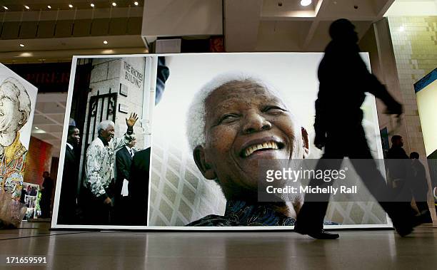 Person walk past a display at the Cape Town Honours Nelson Mandela exhibition at the Cape Town Civic Centre as part of the Cape Town Honours Nelson...
