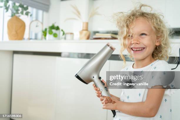 smiling girl having fun blowdrying her hair - secar o cabelo com secador imagens e fotografias de stock