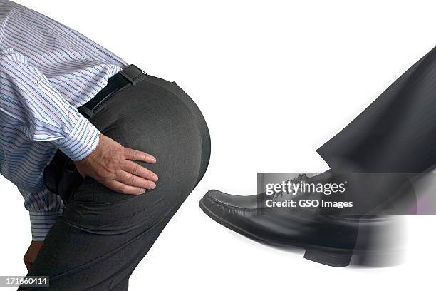 businessman getting a kick up the backside - male buttocks stockfoto's en -beelden