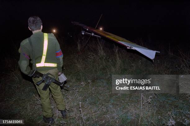 An Israeli soldier looks at the motorized hang glider used in a suicide attack on November 26 at a military camp near Kiryat Shmona in northern...