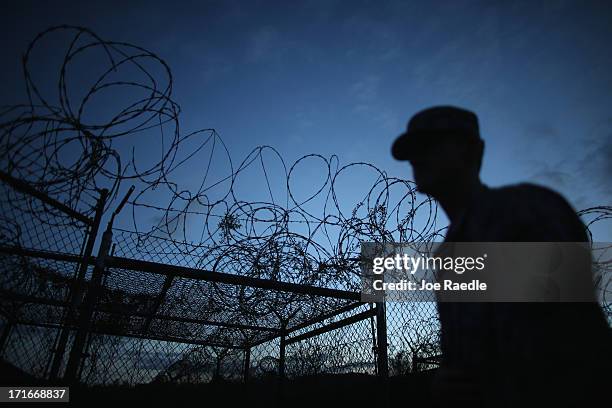 Public Affairs Officer escorts media through the currently closed Camp X-Ray which was the first detention facility to hold 'enemy combatants' at the...