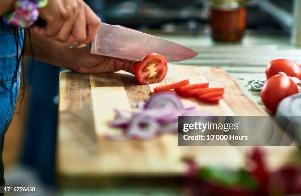 woman chopping tomatoes on wooden board - kitchen knife stock pictures, royalty-free photos & images
