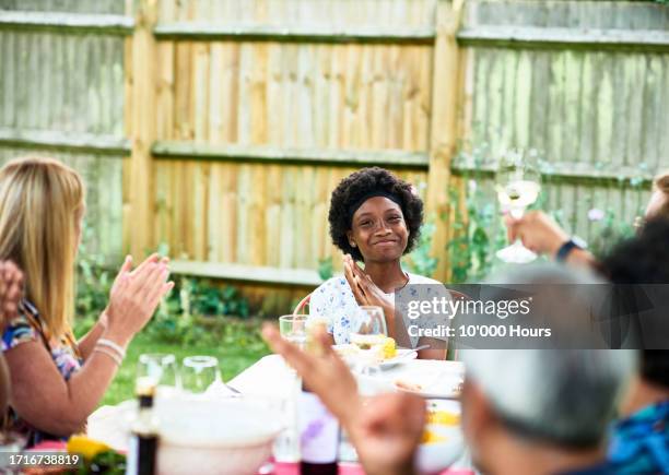 proud looking teenager being congratulated by friends and family - confidence family stock pictures, royalty-free photos & images