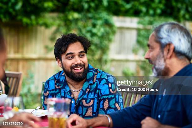 candid shot of cheerful indian man with beard talking to his father - ground culinary stock pictures, royalty-free photos & images