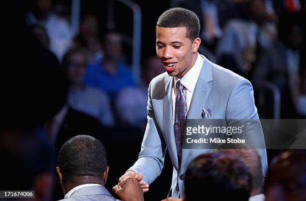 Michael Carter-Williams of Syracuse greets friends and family in the green room after he was drafted overall in the first round by the Philadelphia...