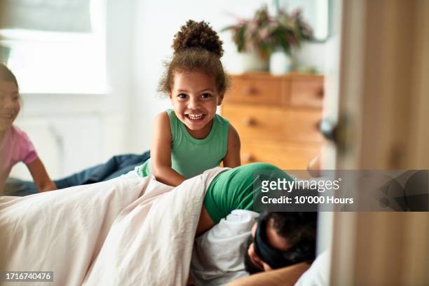 young boy about to wake up his father in bed - kids adults stock pictures, royalty-free photos & images