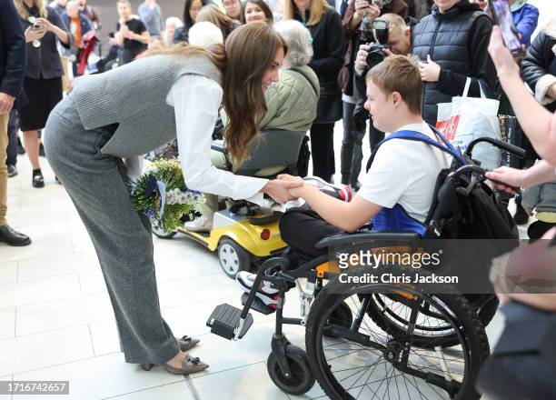 Catherine, Princess of Wales smiles and speaks with a well-wisher in a wheelchair during her visit to Vsi Razom Community Hub, in the Lexicon...