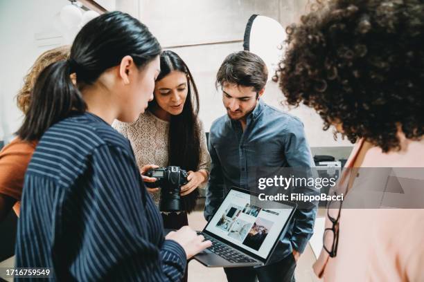 un fotografo sta dando un'occhiata alle immagini con modelle e registi - director foto e immagini stock