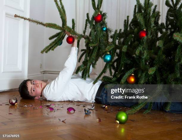 christmas tree fell on young man - broken christmas bauble stock pictures, royalty-free photos & images