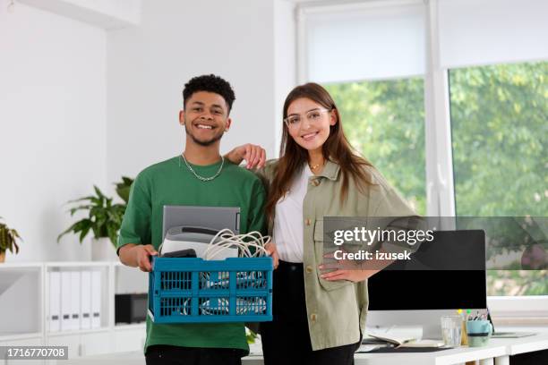 portrait of smiling young colleagues carrying container for recycling at office - man holding donation box stock pictures, royalty-free photos & images
