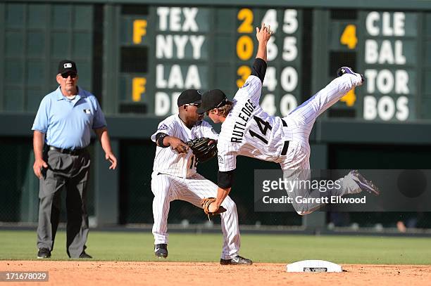 Jonathan Herrera collides with Josh Rutledge of the Colorado Rockies while trying to catch a ball off the bat of Daniel Murphy of the New York Mets...