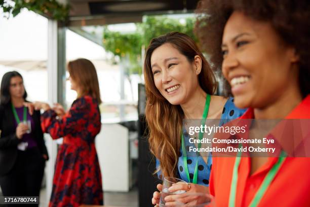 smiling businesswomen relaxing at business conference - senior lifestyles stock pictures, royalty-free photos & images