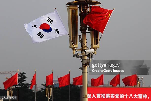 Chinese and South Korean flags flutter in front of Tiananmen Rostrum on June 27, 2013 in Beijing, China. South Korean President Park Geun-Hye is on a...