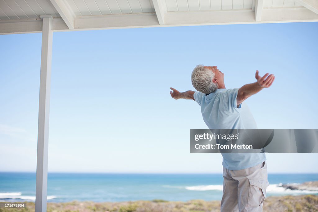 Senior man standing with arms outstretched