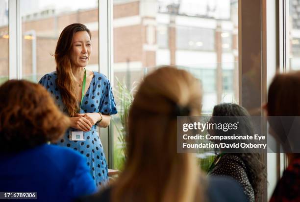 asian businesswoman giving speech at women's networking event - build series presents jennifer lopez and ray liotta discussing shades of blue stockfoto's en -beelden