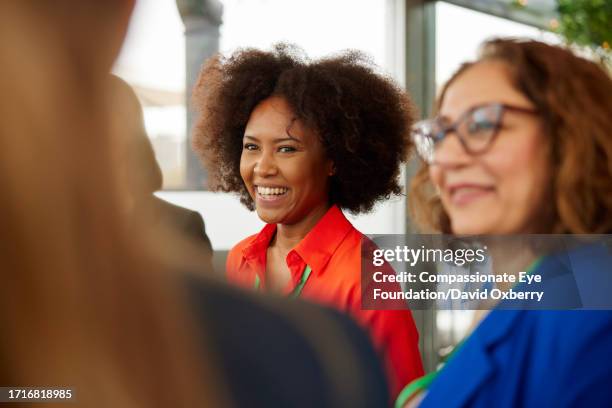 businesswomen talking at networking event - kleine scherptediepte stockfoto's en -beelden