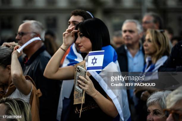 Woman holds an Israeli flag during a rally in solidarity with Israel following the surprise assault on Israel by the Palestinian militant group Hamas...