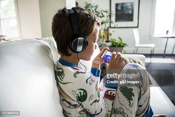 boy in headphones playing video games on ipod - boy ipod bildbanksfoton och bilder