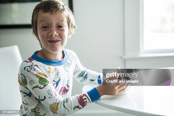 boy in pajamas eating cereal - boy eating cereal foto e immagini stock