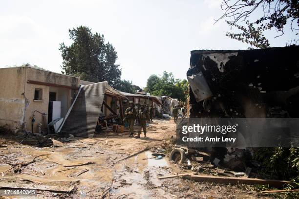Israeli soldiers patrol near burned houses after an attack by Palestinian militants on this kibbutz near the borde with Gaza on October 10, 2023 in...
