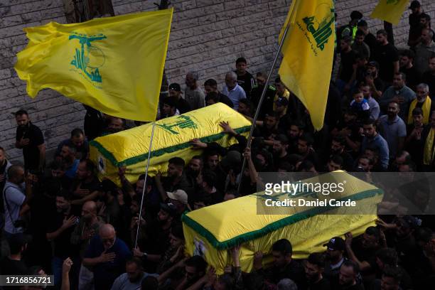 People carrying the coffins as the precession makes its way to the cemetery at a funeral for two Hezbollah soldiers who were killed yesterday by...