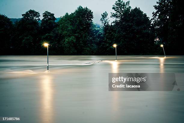 lamps in flooding water on evening - germany flood stock-fotos und bilder