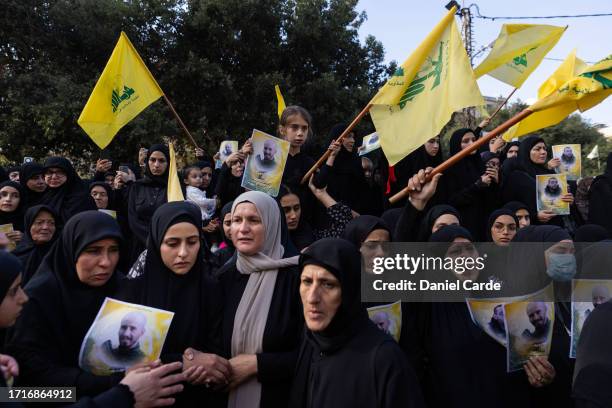 Women hold pictures at a funeral for two Hezbollah soldiers who were killed yesterday by Israel Defense Forces in South Lebanon on October 10, 2023...