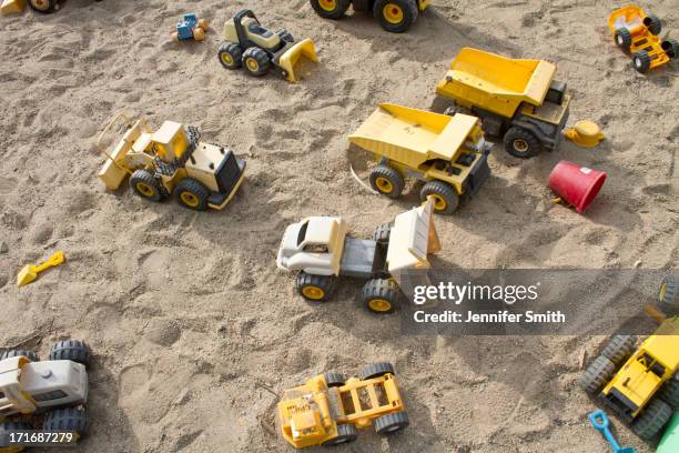 toy trucks in a sandbox - sandkasten stock-fotos und bilder