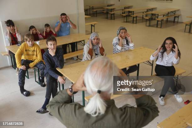 Migrants, including Temuri Gurjia and his wife and three children, attend a German language class at a shelter for migrants and refugees inside a...