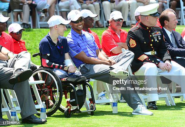 Tiger Woods chats with Brendan Marrocco, the first US soldier to survive quadruple amputation and to receive a bilateral arm transplant, during...