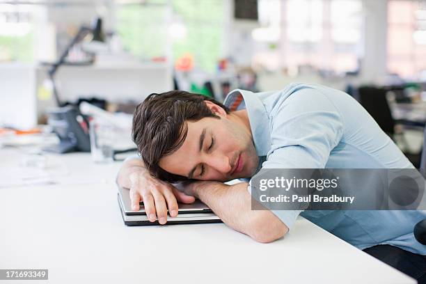 businessman sleeping on laptop at desk in office - napping stock pictures, royalty-free photos & images