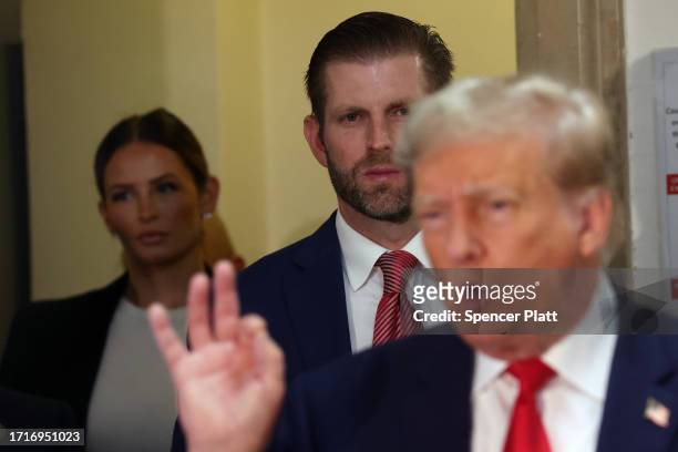 Eric Trump stands behind his father former U.S. President Donald Trump as he speaks to the media on the third day of his civil fraud trial at New...