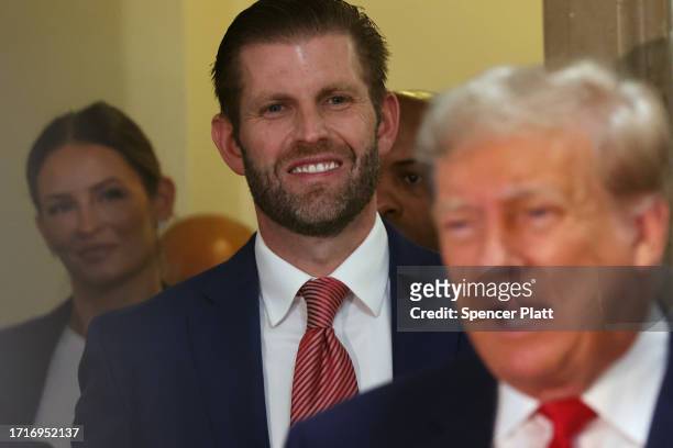 Eric Trump stands behind his father former U.S. President Donald Trump as he speaks to the media on the third day of his civil fraud trial at New...