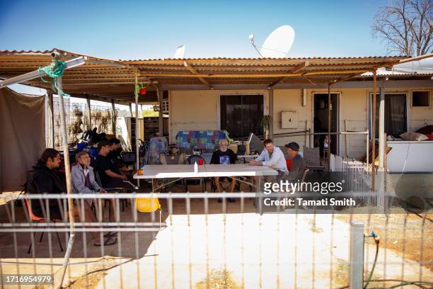 Group of people sit at the front of one of the houses in the community on October 04, 2023 in Pia Wadjarri, Australia. A referendum for Australians...