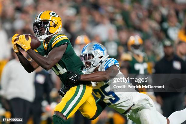 Jayden Reed of the Green Bay Packers makes a catch against Will Harris of the Detroit Lions during the third quarter in the game at Lambeau Field on...