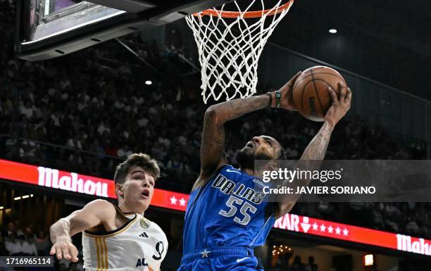 Dallas Mavericks' forward Derrick Jones Jr. Jumps to score next to Real Madrid's Spanish guard Hugo Gonzalez during the NBA Preseason game between...