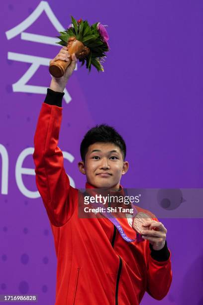 Tamai Rikuto of Japan poses with his medal on the medal ceremony after the Diving Men's 10m Platform Final Final during day eleven of the 19th Asian...