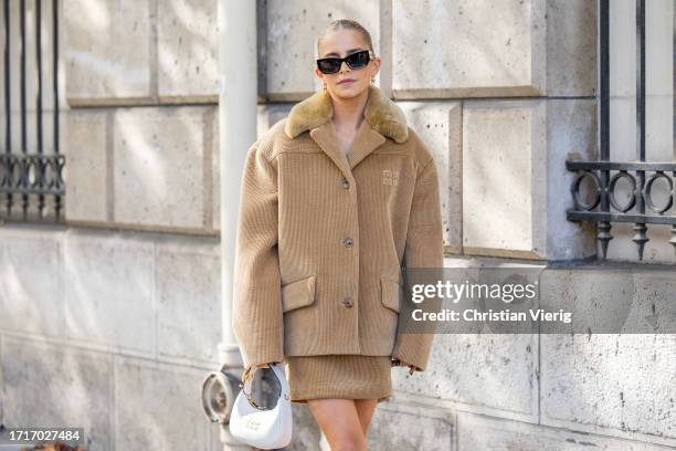 Caroline Caro Daur wears oversized beige jacket, skirt, white bag, sunglasses outside Miu Miu during the Womenswear Spring/Summer 2024 as part of...