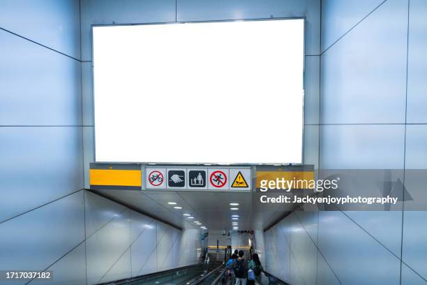 on the wall of a subway station, a blank billboard advertising banner media display - poster subway stock-fotos und bilder