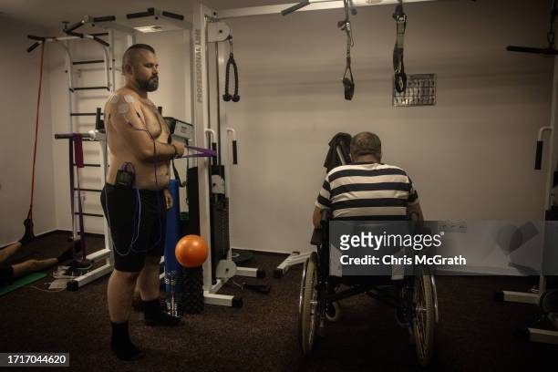 Year-old soldier Andriy, and 52 year-old amputee soldier Valeriy take part in a physical therapy session at a rehabilitation center for soldiers...