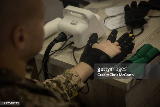 Oleksander suffering from a hand injury uses a glove to build up hand muscles and improve mobility at a rehabilitation center for soldiers suffering...