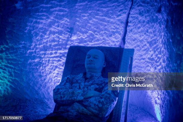 Oleksander suffering from a hand injury relaxes during a speleotherapy session, at a rehabilitation center for soldiers suffering from injuries and...