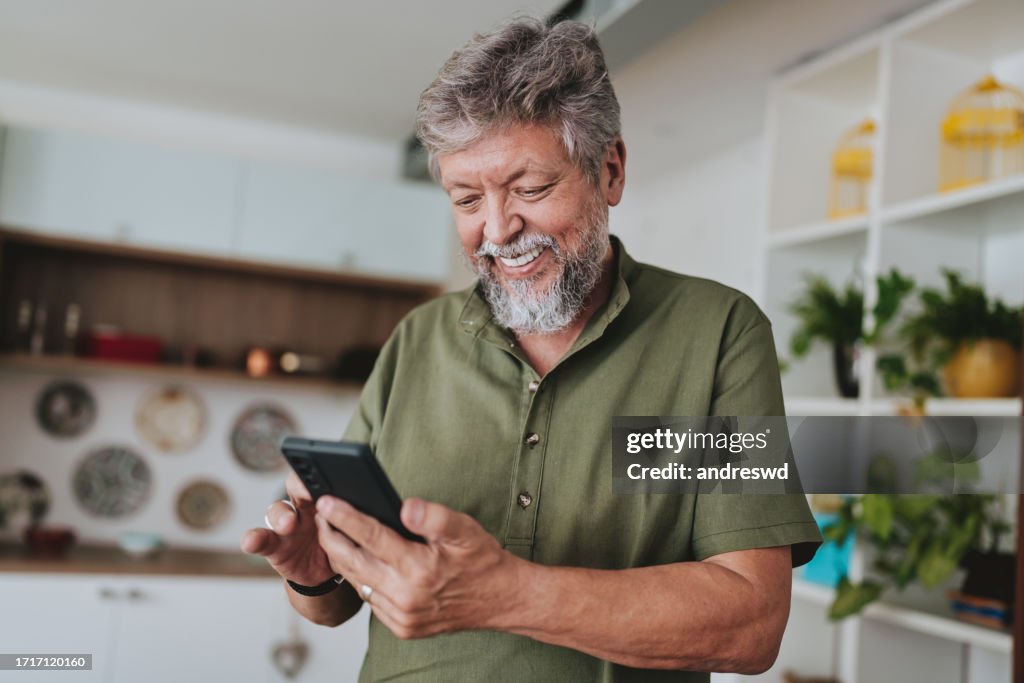 Portrait of a senior man using smartphone at home