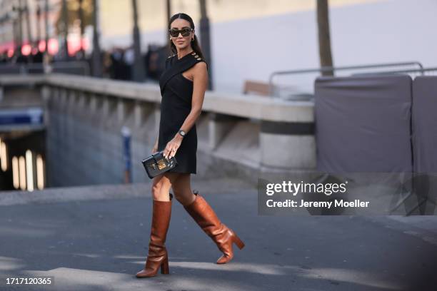 Tamara was seen wearing brown heels, Louis Vuitton petite malle bag, dark shades, a silver watch and a black dress with yelllow gold ornaments on her...